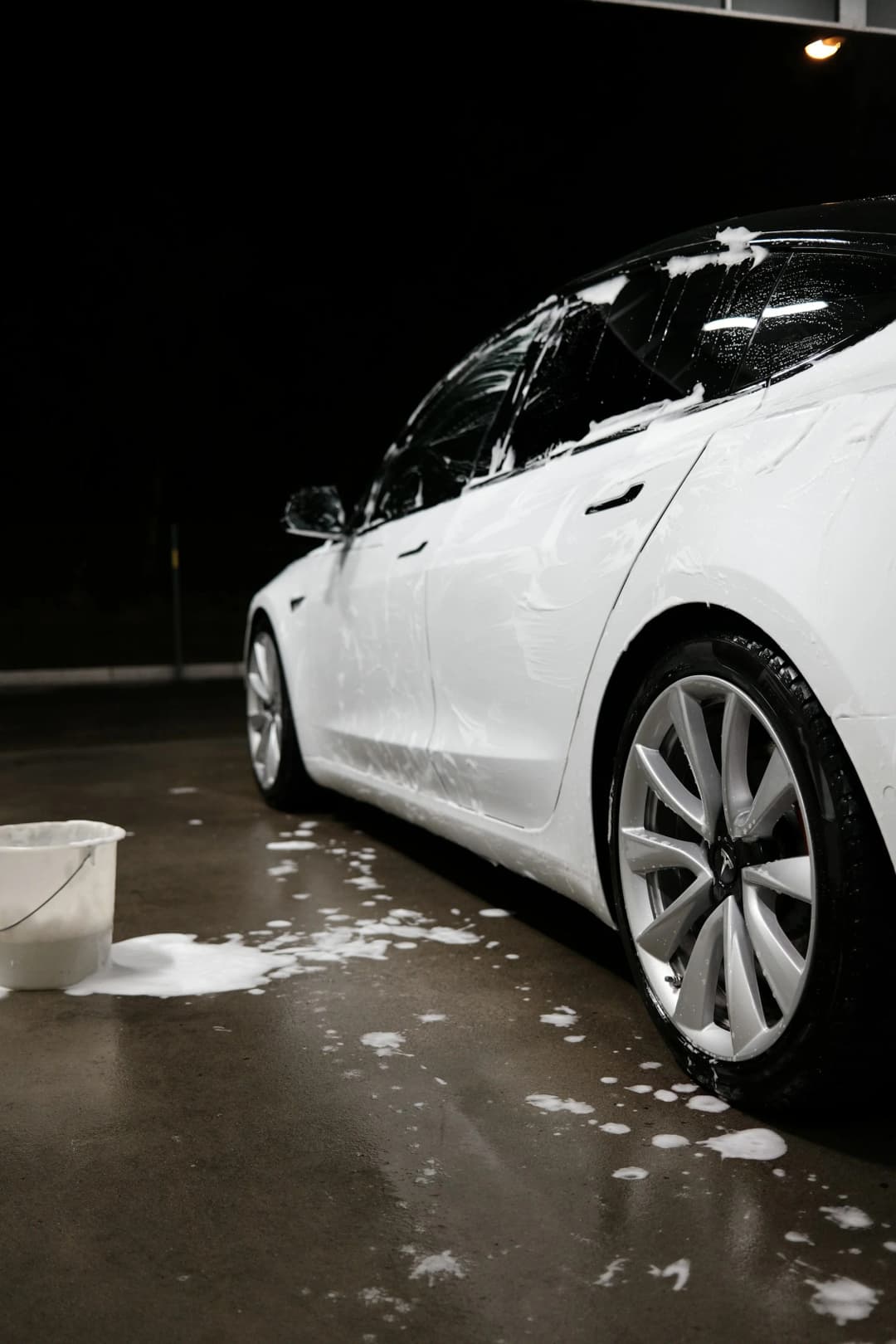 A white Tesla washed in a self service car wash